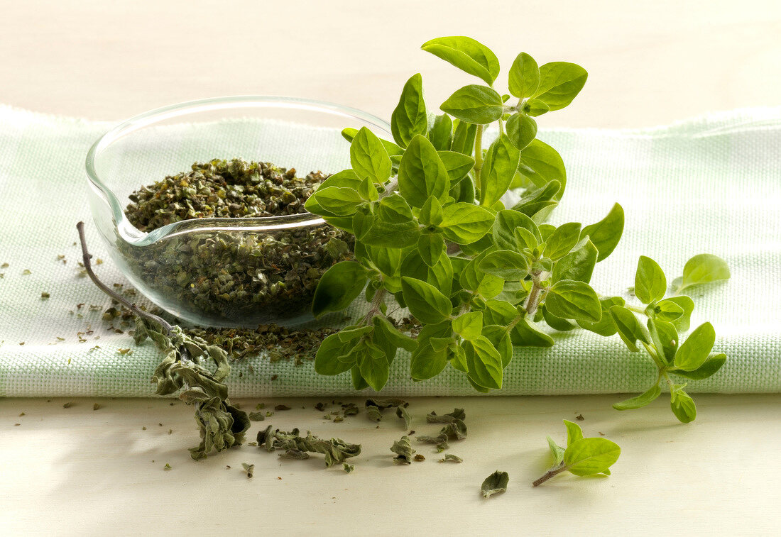 Fresh and dried marjoram in glass bowl