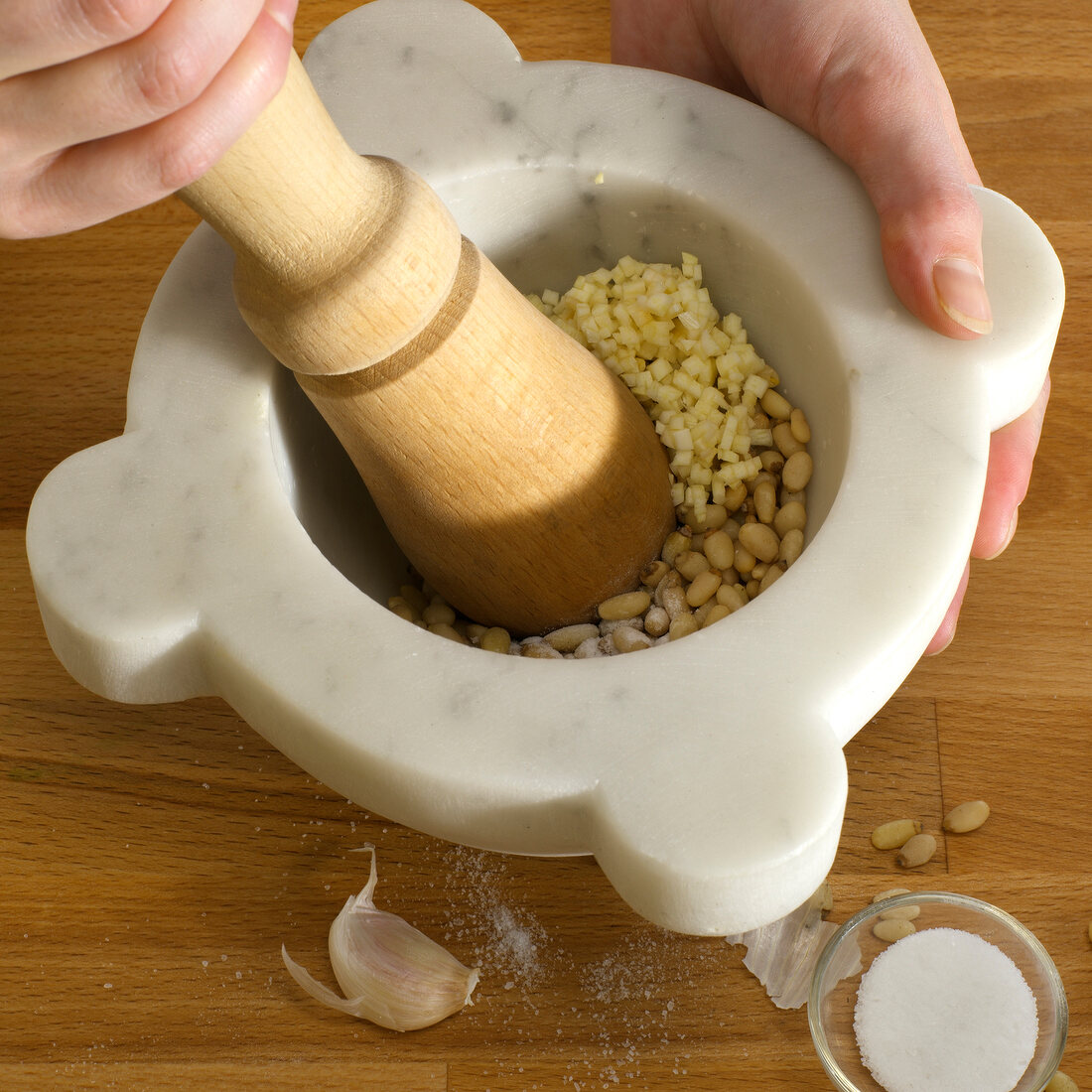Pine kernels being crushed in mortar, step 1
