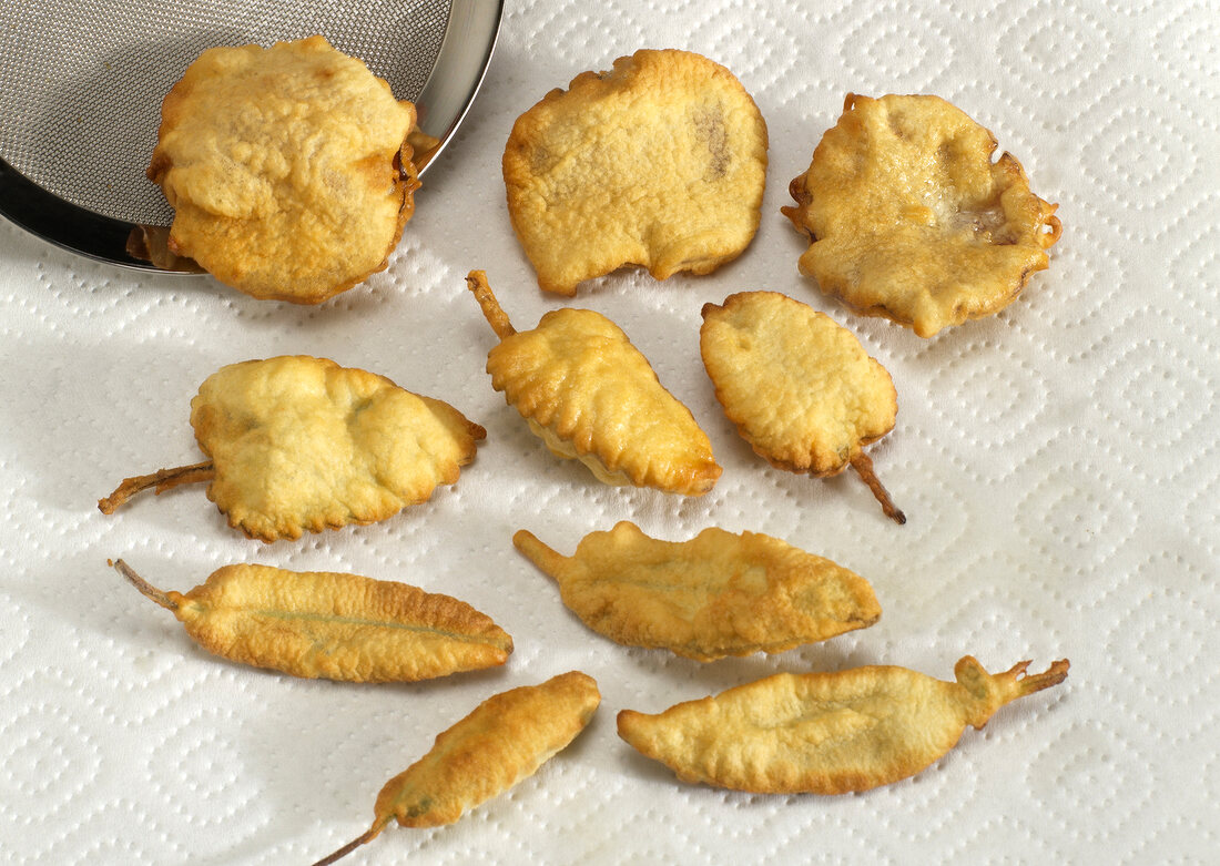 Fried petals and herb being placed on tissue paper, step 6