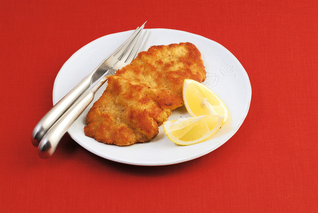 Grilled wiener schnitzel with lemon on plate