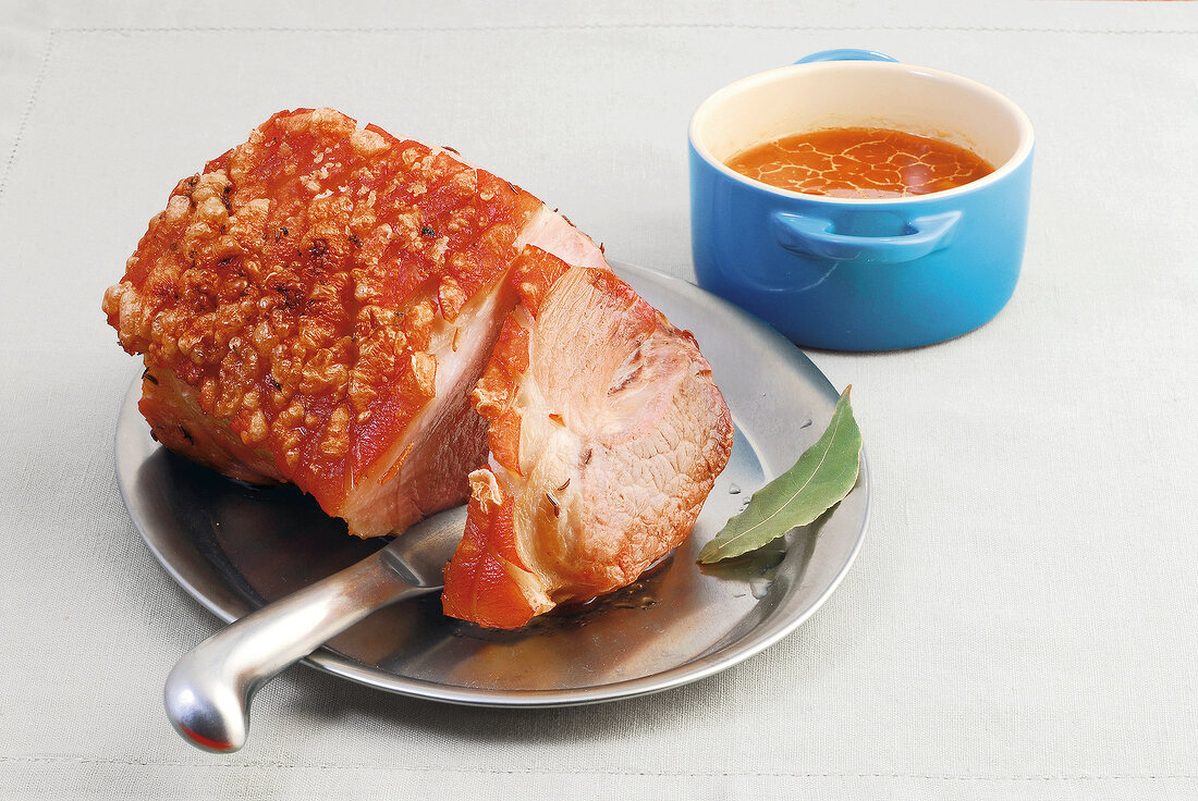Close-up of crispy roasted pork with beer sauce on plate