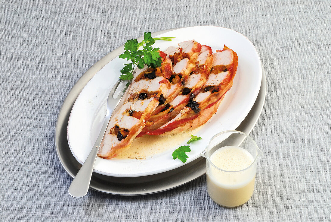 Turkey breast with dried fruit filling and cream sauce in serving bowls