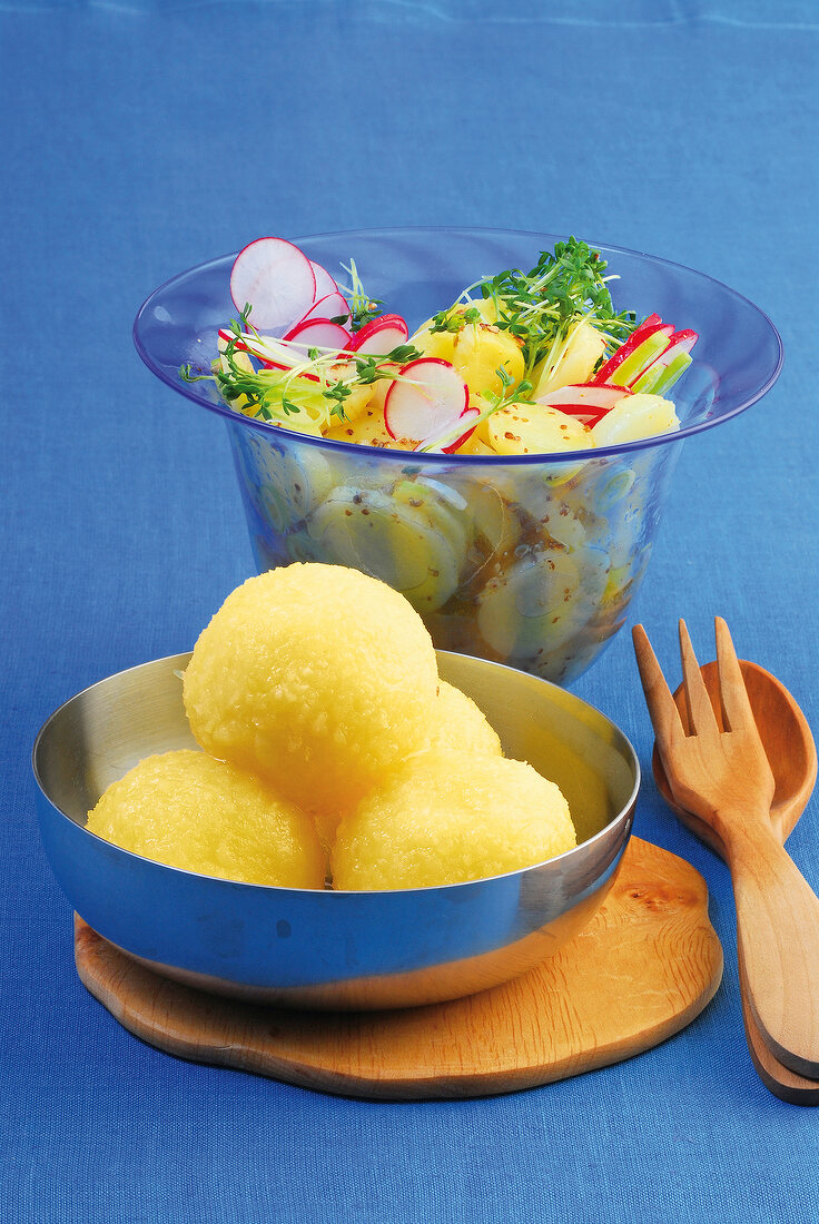 Potato salad with radish and potato dumplings in serving dish