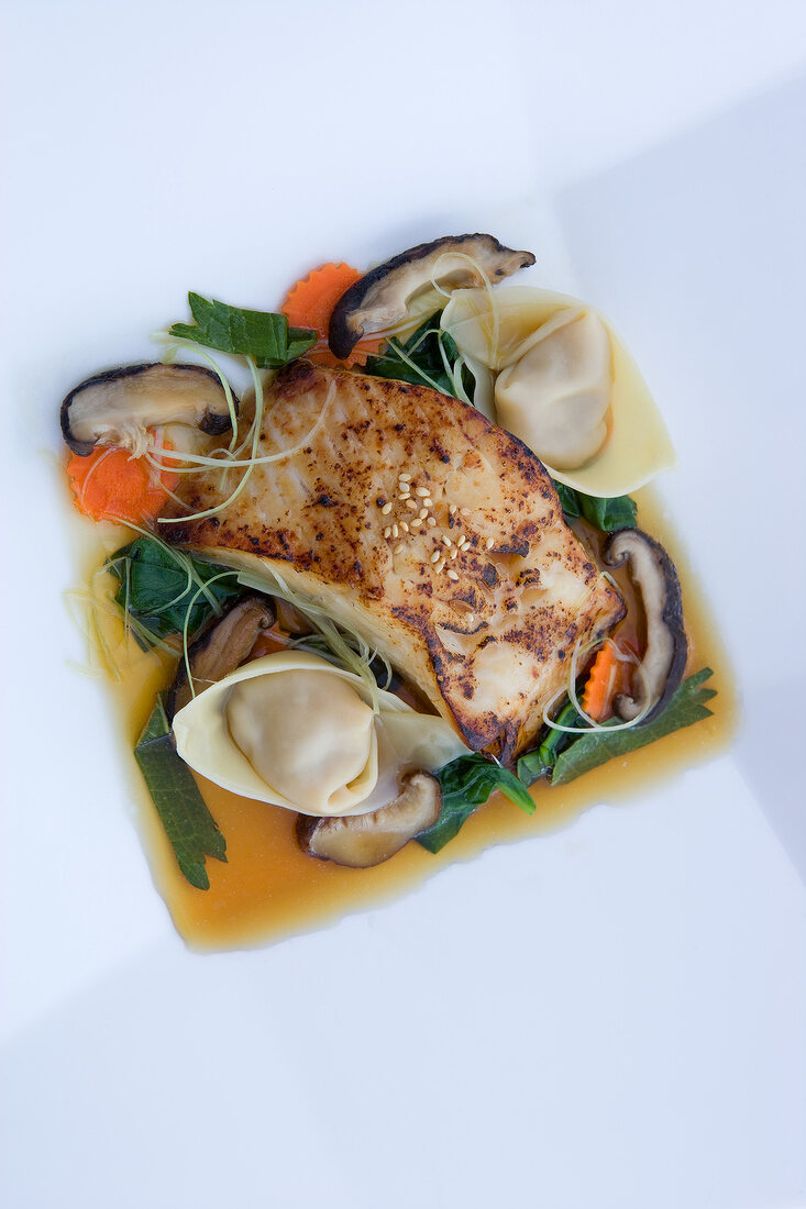 Close-up of cod with shrimp dumplings and shiitake mushrooms, overhead view