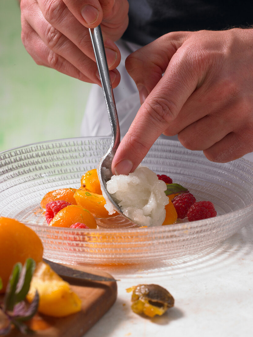 Adding granita to fruits in bowl