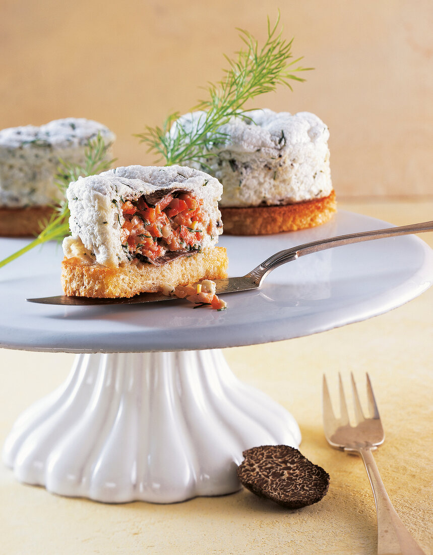 Close-up of meringue tarts truffle with salmon tartare core on cake stand