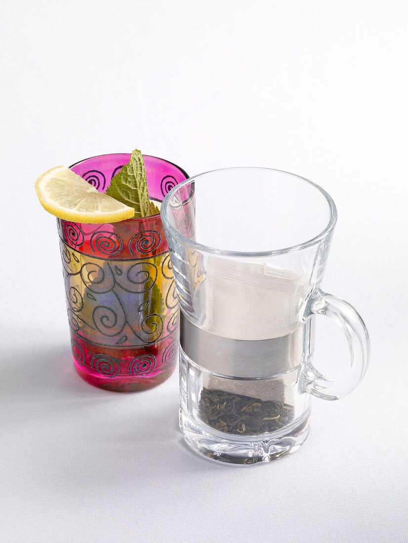 Oriental decorated glasses with tea bags on white background