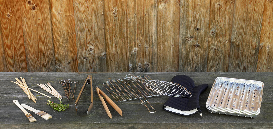 Grill accessories, grill tools, pliers and glove on wooden table