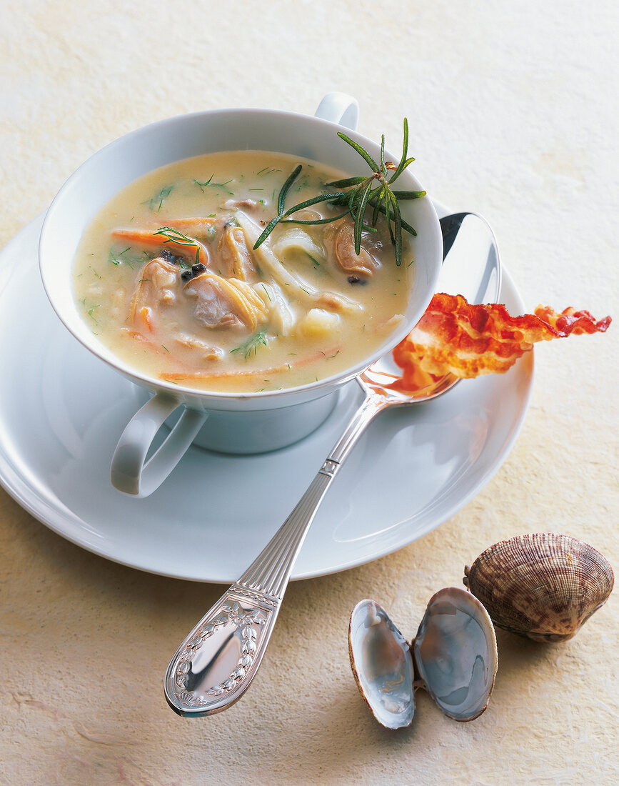 Clam soup with pancetta and rosemary in bowl on plate
