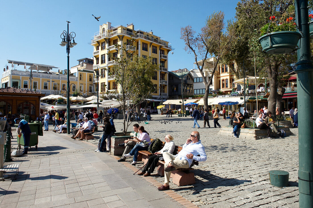 People sitting on benches in market place in Istanbul, Turkey