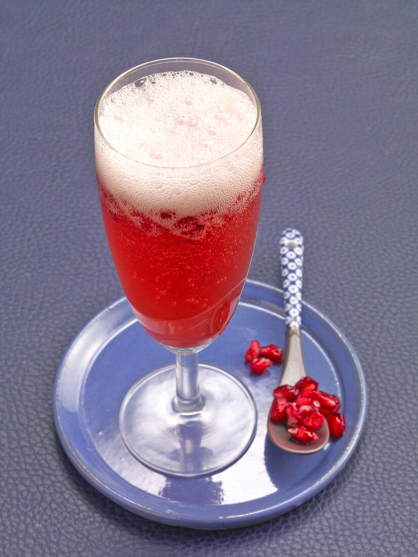 Pomegranate champagne in champagne glass with pomegranate seeds