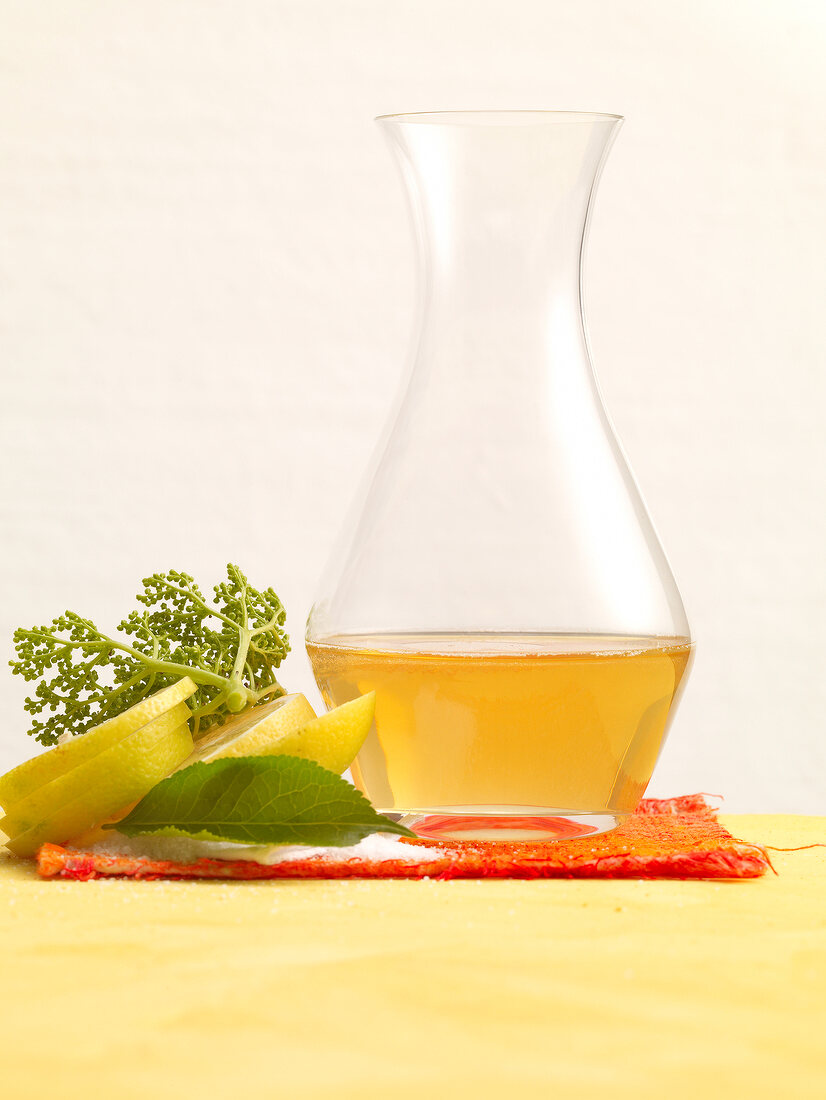 Elderflower syrup in carafe with lemon and elderberry