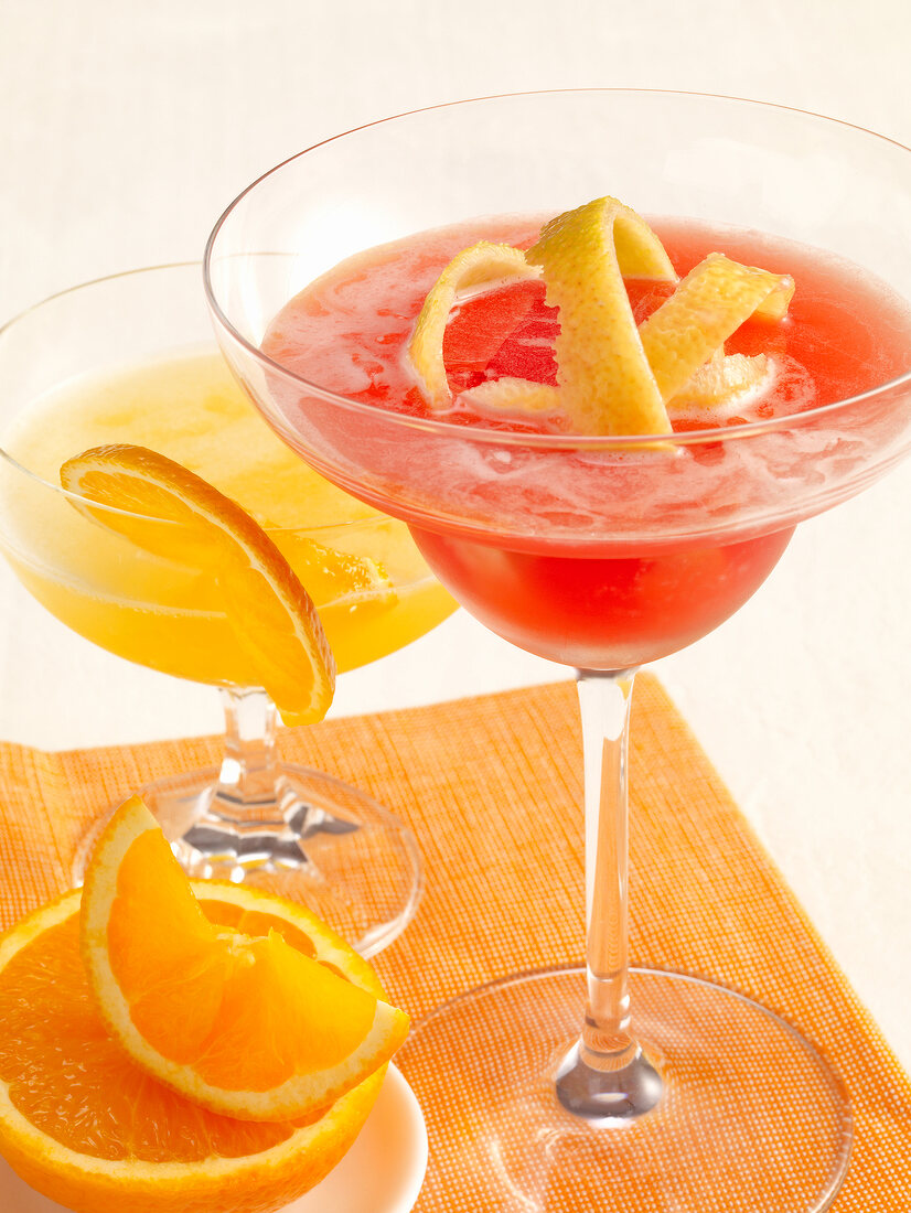 Two fruit cocktails with orange and lemon slices