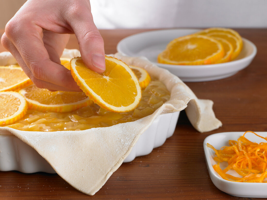 Orange slices being placed on fennel cream in tart, step 2
