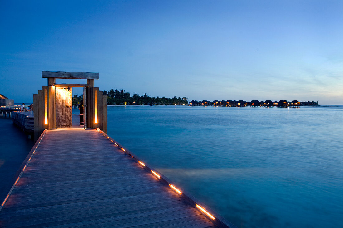beleuchteter Steg ragt ins Wasser, Insel Veliganduhuraa, Malediven