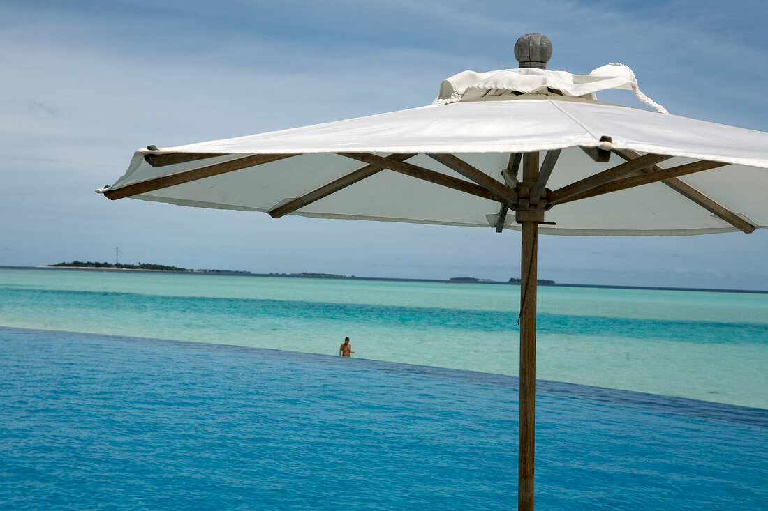Parasol at swimming pool in front of sea, Dhigufinolhu island, Maldives