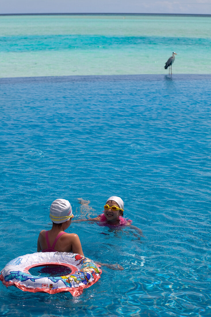 Two children at pool in Dhigufinolhu Island, Maldives