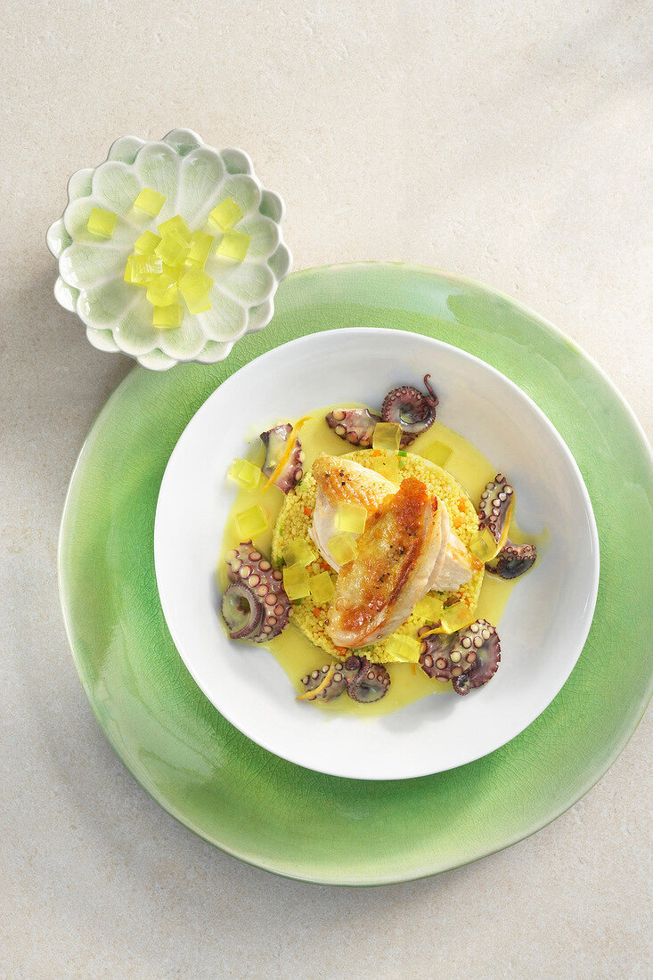 Chicken ragout with octopus, orange sauce and lemon jelly on plate