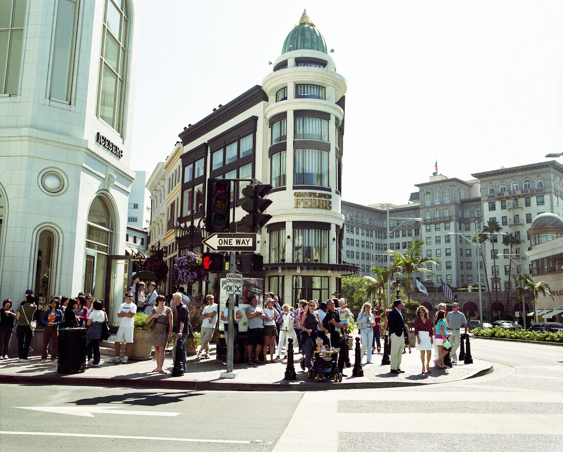 People standing under the sun waiting for traffic light in Los Angeles, California, USA