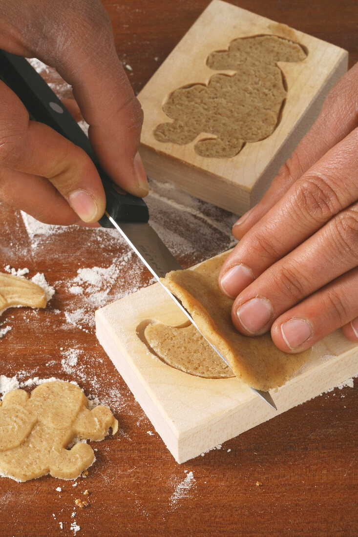 Excess dough being cut from mould with knife for baking speculoos for Christmas, step 3