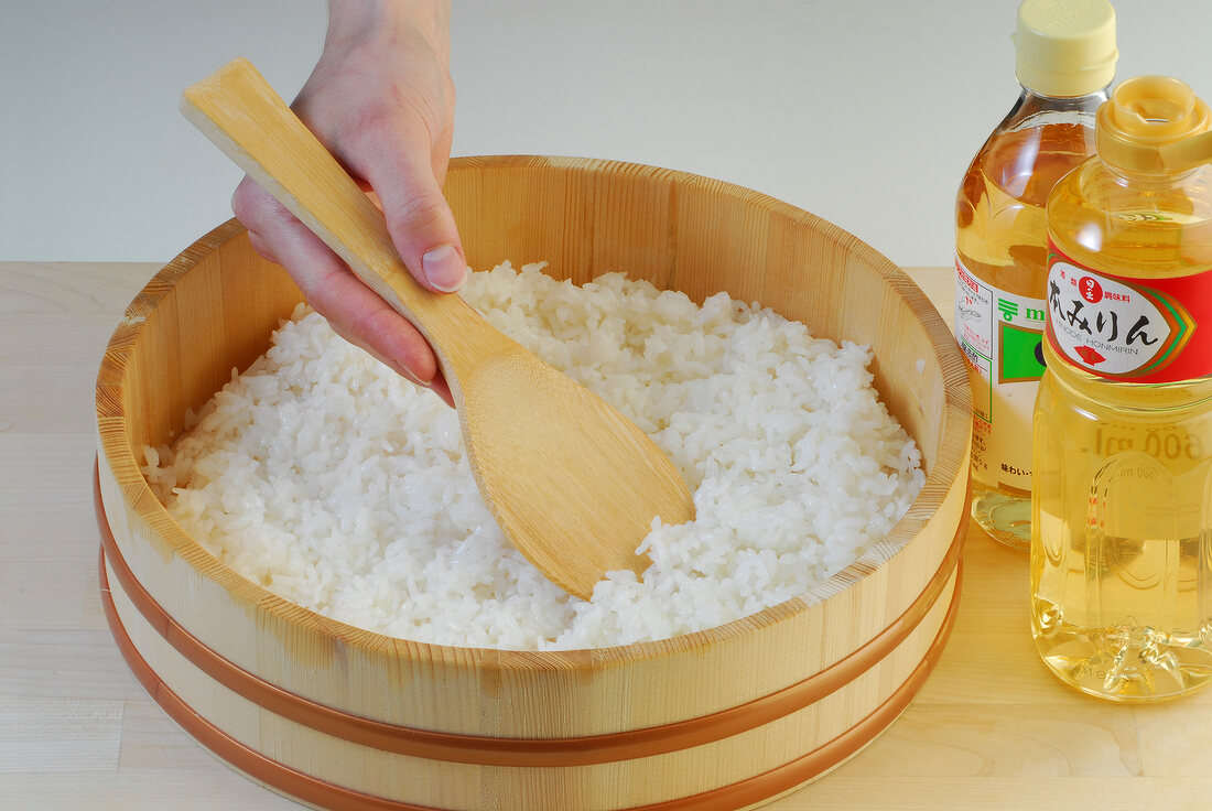 Sushi rice in wooden bowl with wooden spoon for preparation of sushi, step 3