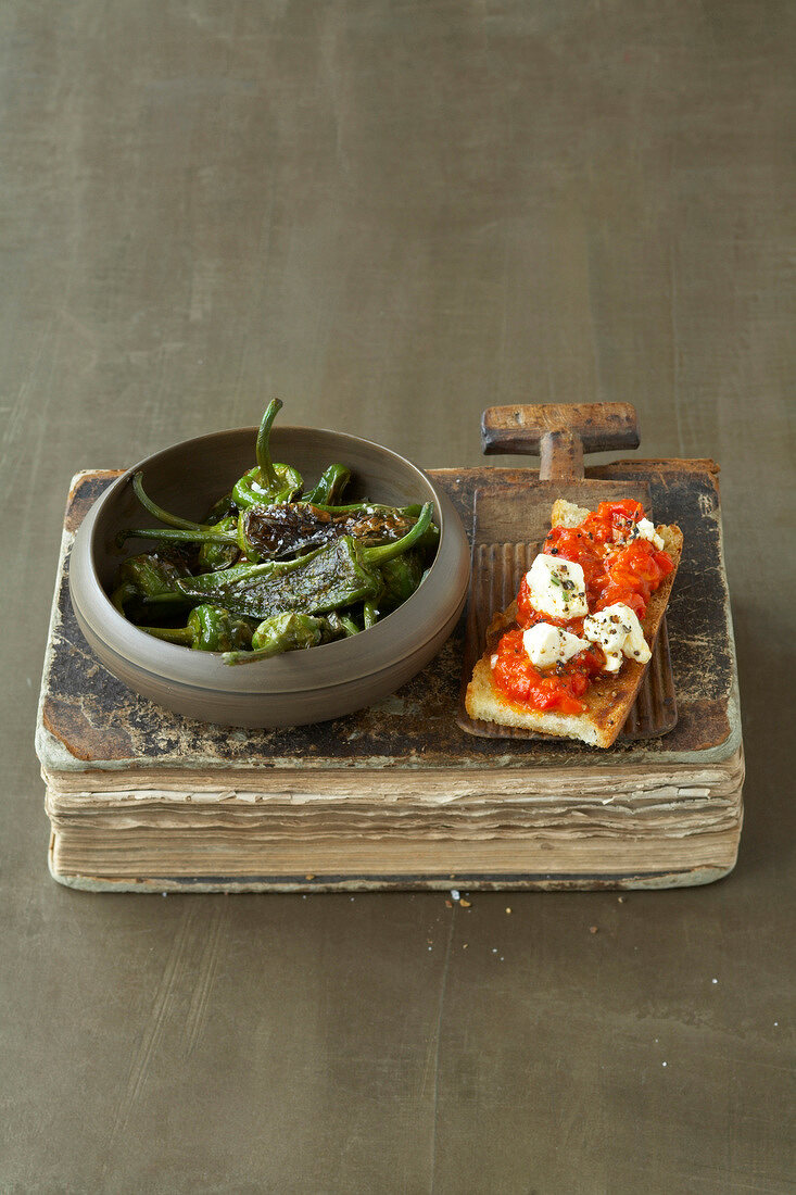 Padron peppers and croutons beside bowl of pepper and feta spread