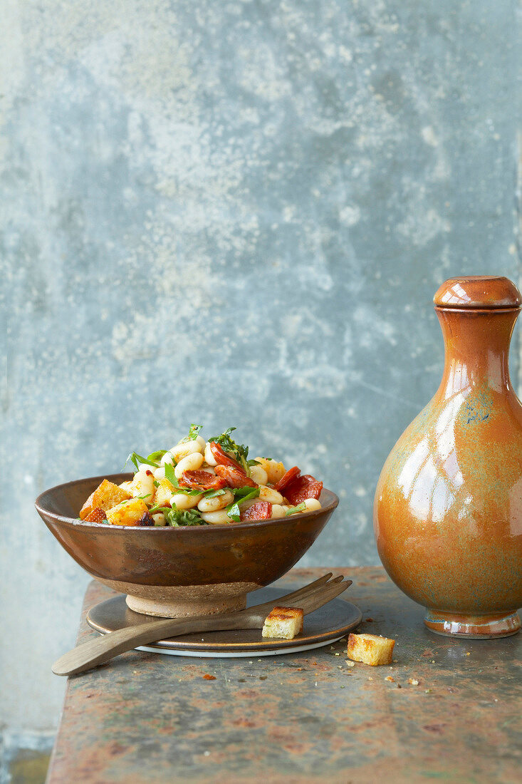 Salad with white beans, croutons and chorizo in bowl