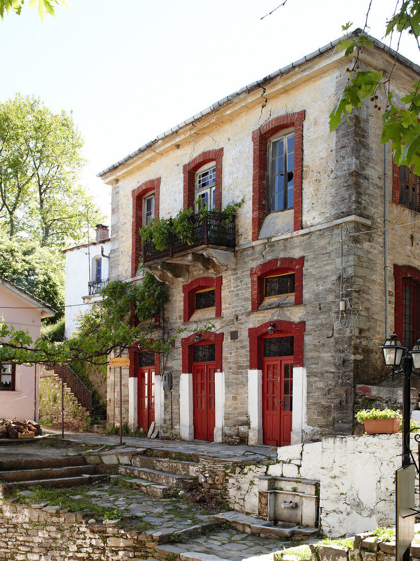 Exterior of house with red doors in Greece