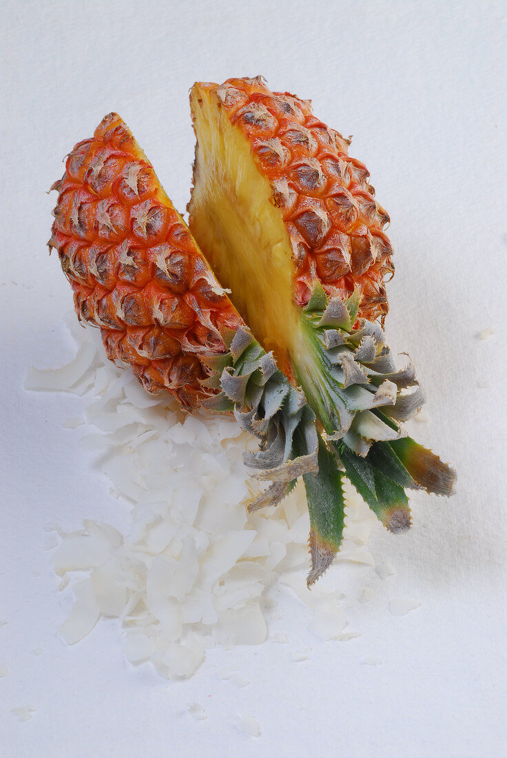 Halved pineapple on pieces of coconut