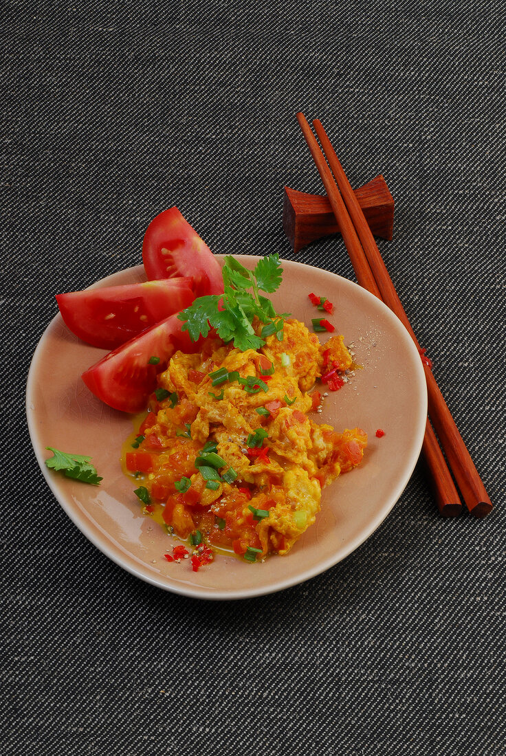 Spicy tomato scrambled eggs with coriander on plate