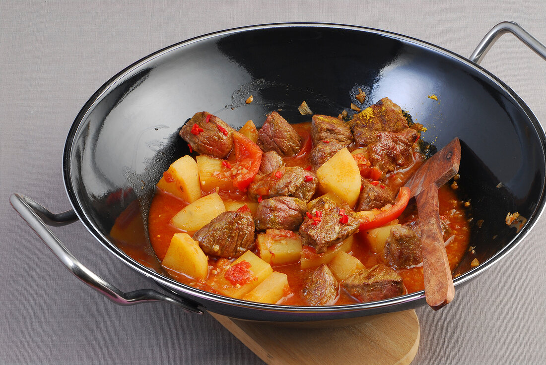 Wok, Rindfleisch-Curry mit Tomaten und Kartoffeln im Wok