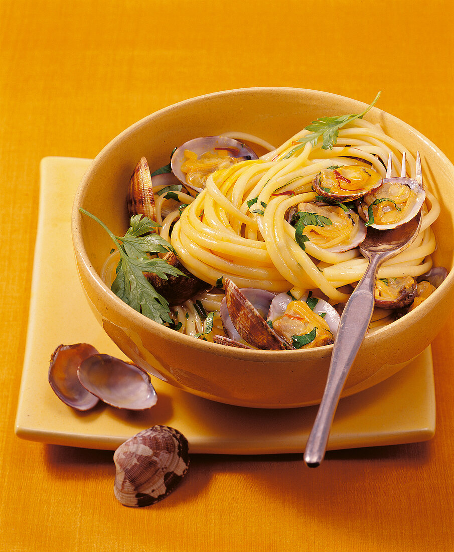 Saffron pasta with clams and parsley in bowl