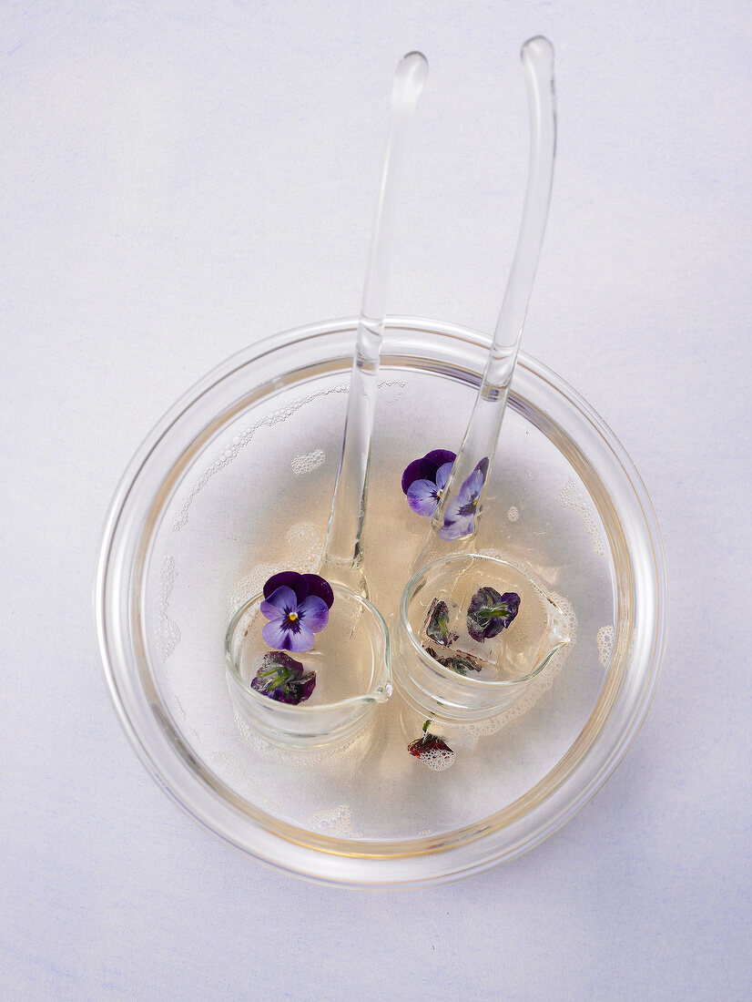 Woodruff punch with blue flowers in bowl with two scoops
