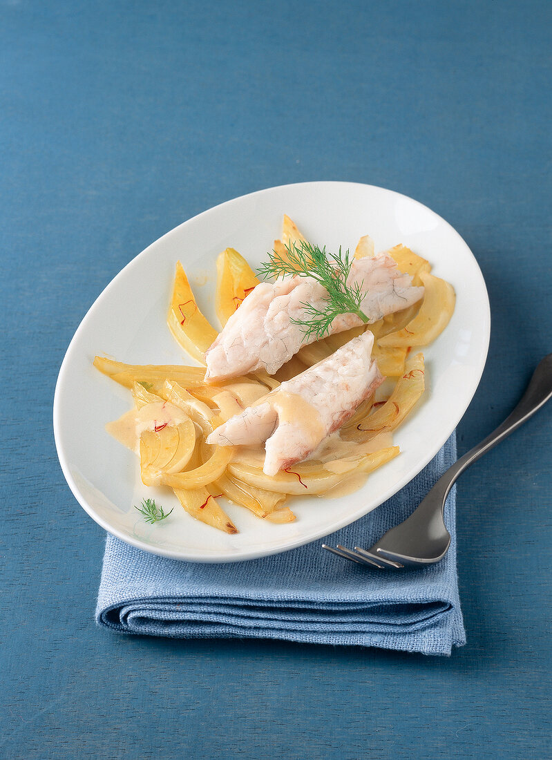 Sea bass with pernod cream, saffron fennel and anise sauce in plate