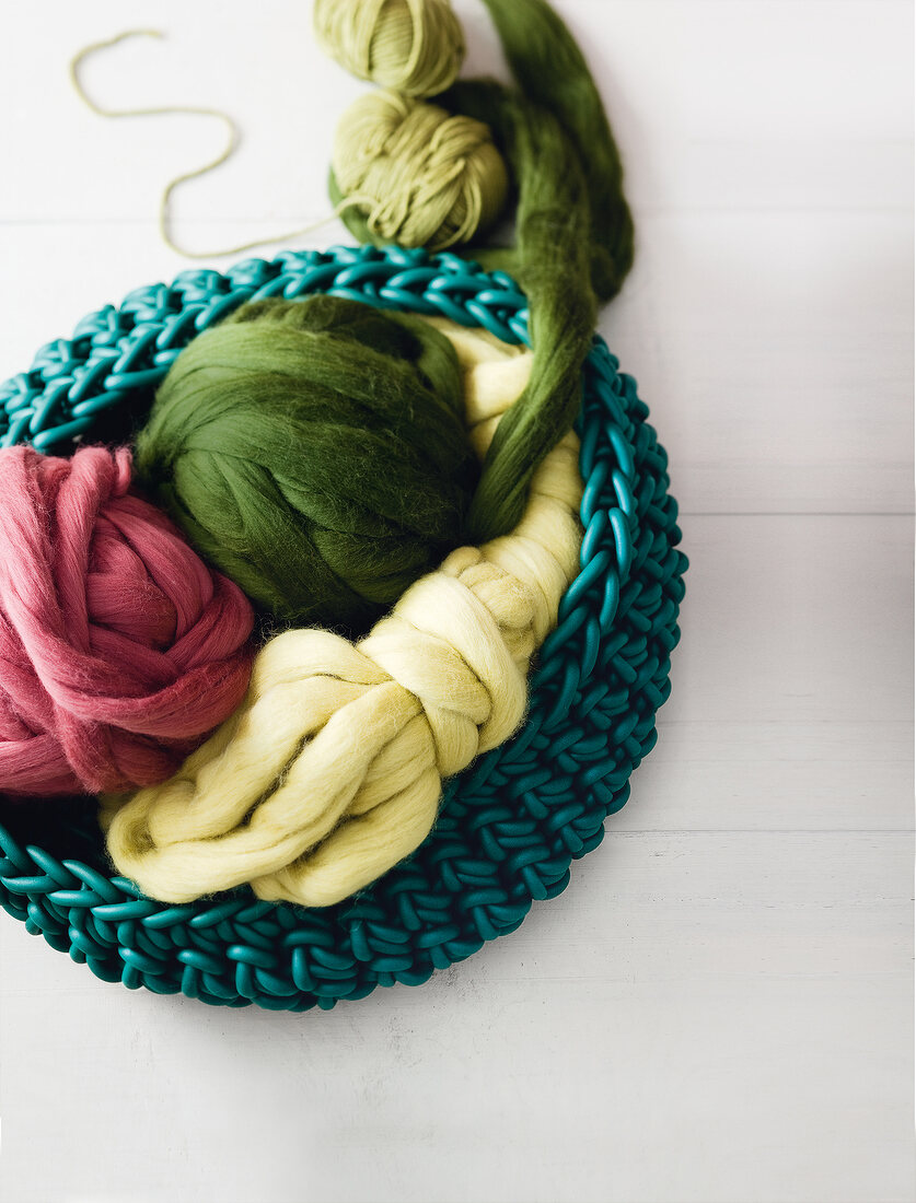 Colourful balls of wool in basket on white background