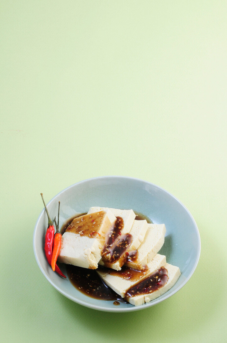 Tofu with spicy-sweet sam-honey marinade and chili peppers in bowl
