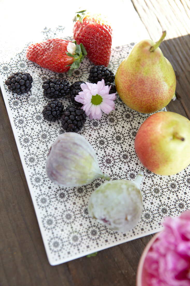 Beeren, Äpfel und Feigen auf Keramikplatte