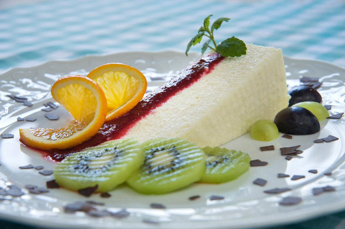 Semolina pudding with raspberry puree, orange, kiwi, grapes and chocolate on plate