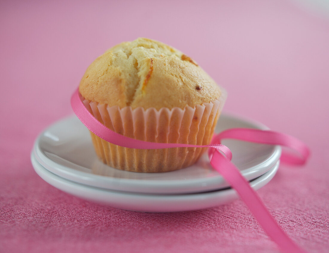 Orange and chilli muffin with pink ribbon on plate