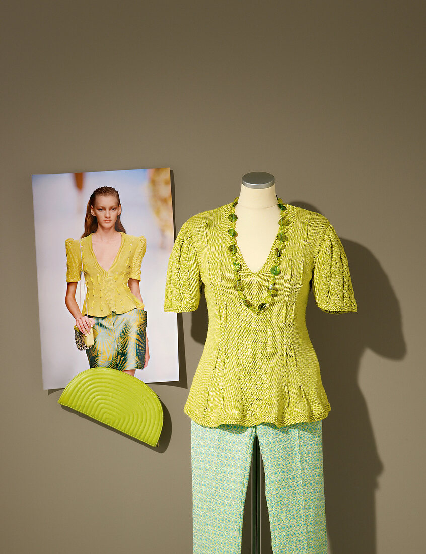 Green knit sweater, pants and chain on mannequin