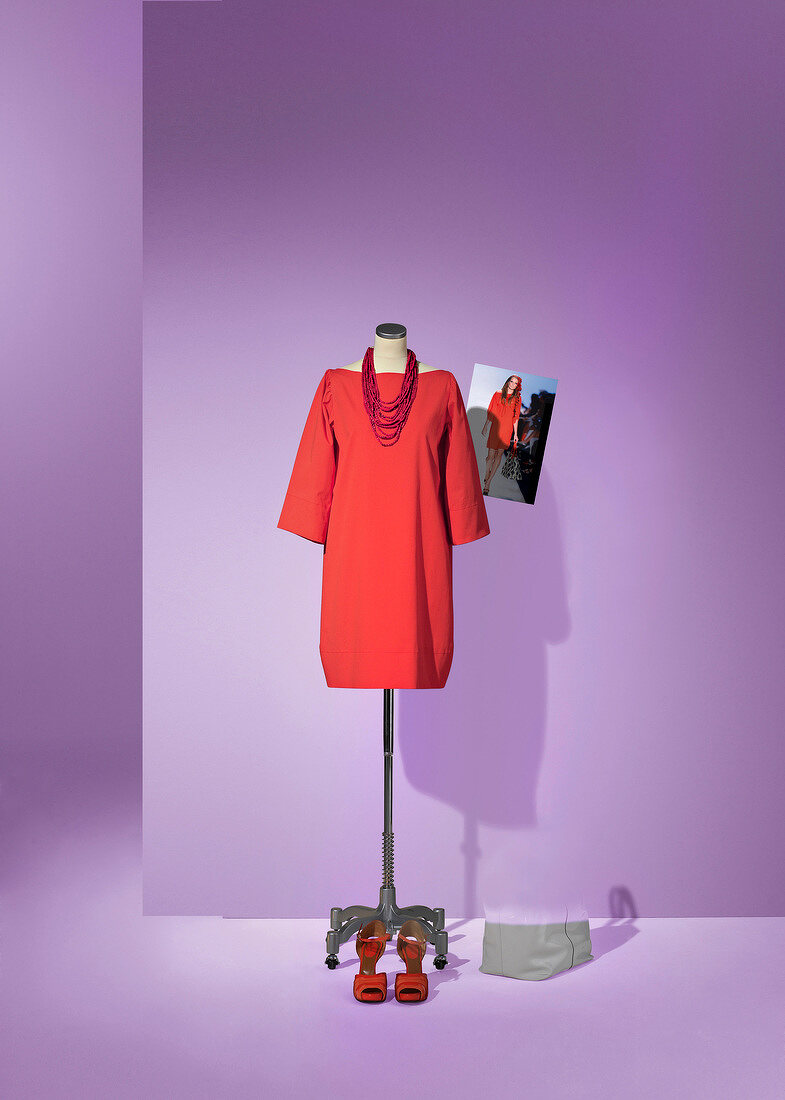 Red dress with chain displayed on dressmakers model