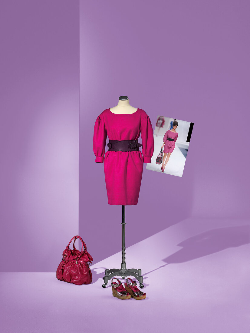 Pink dress on mannequin with waist bag and shoes by side