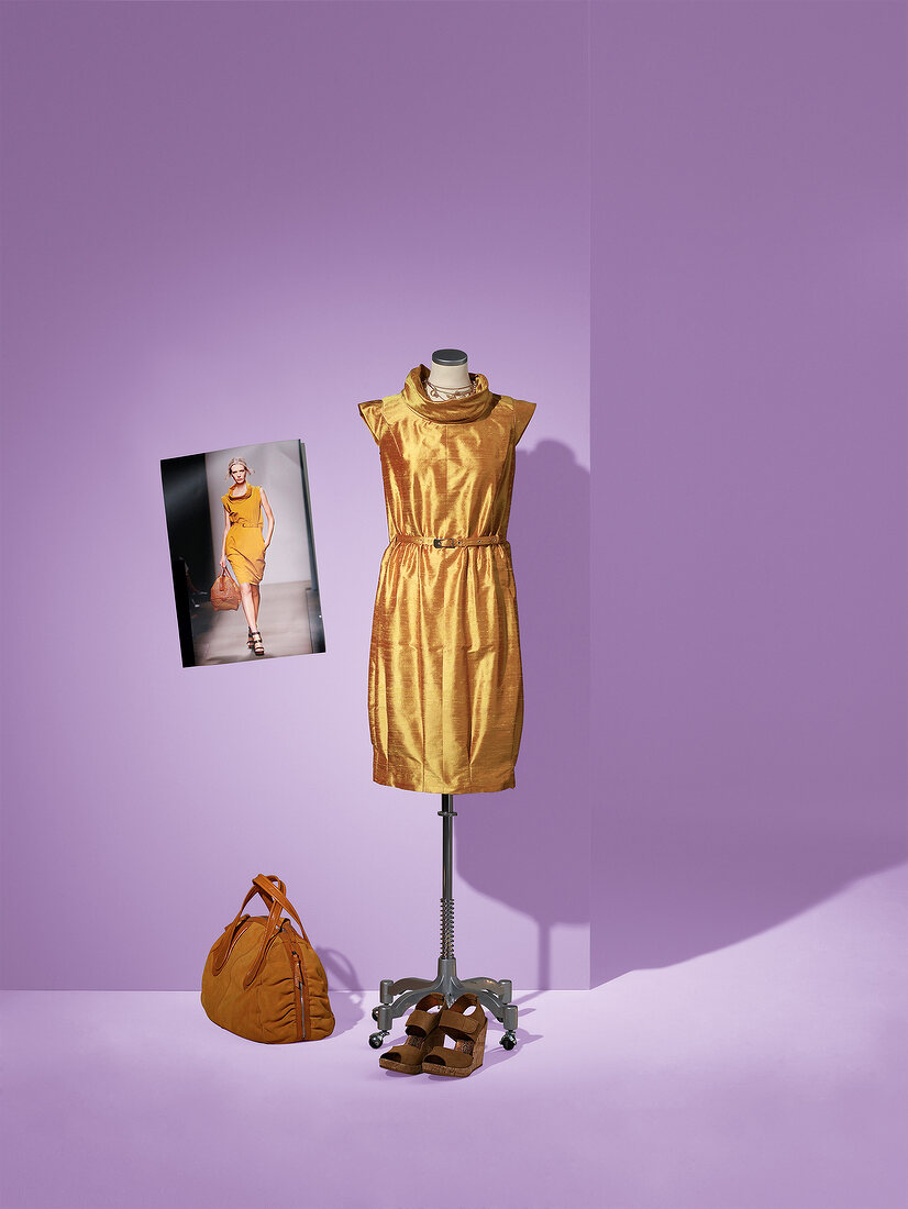 Gold silk taffeta dress on mannequin with bag and shoes on side