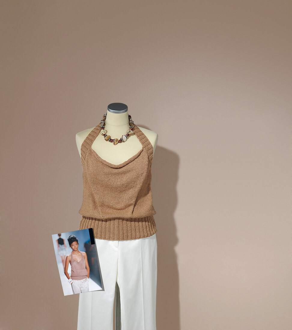 Overall knit halter top with white pants on mannequin