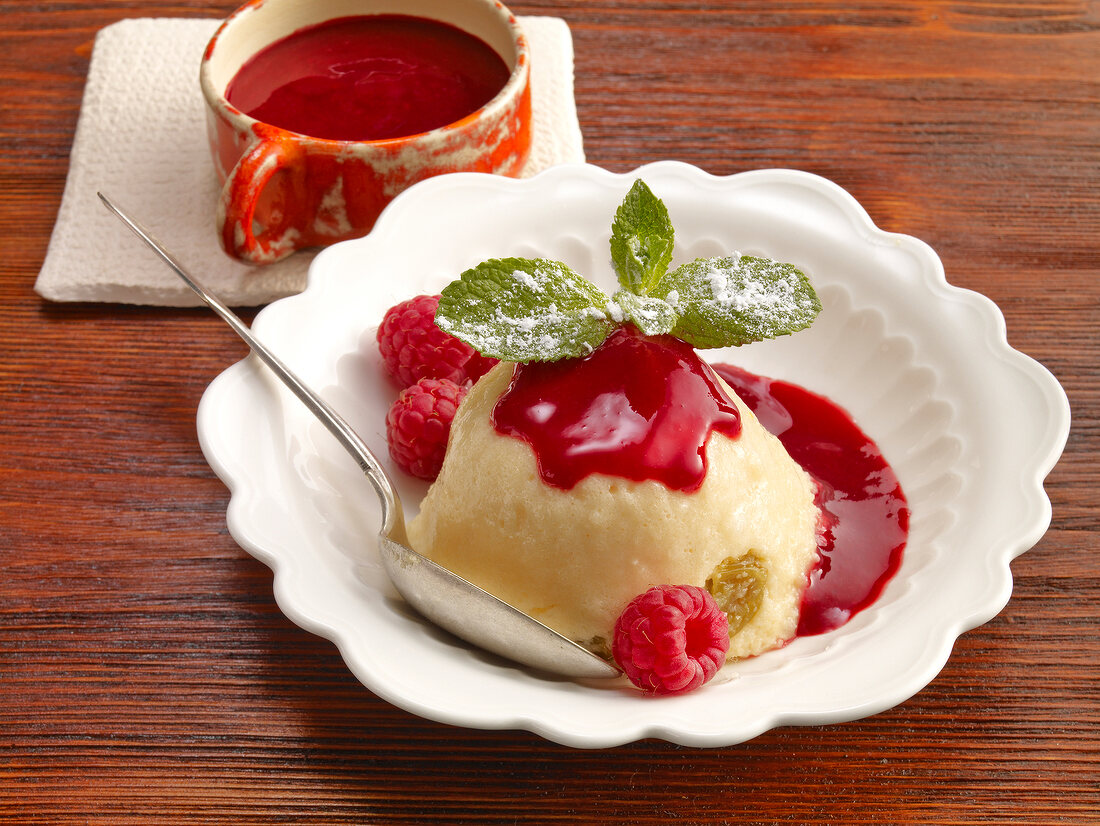 Semolina pudding with raspberries and raspberry sauce in serving dish