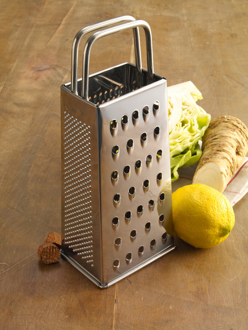 Lemon, radish, lettuce and nutmeg with grater on table