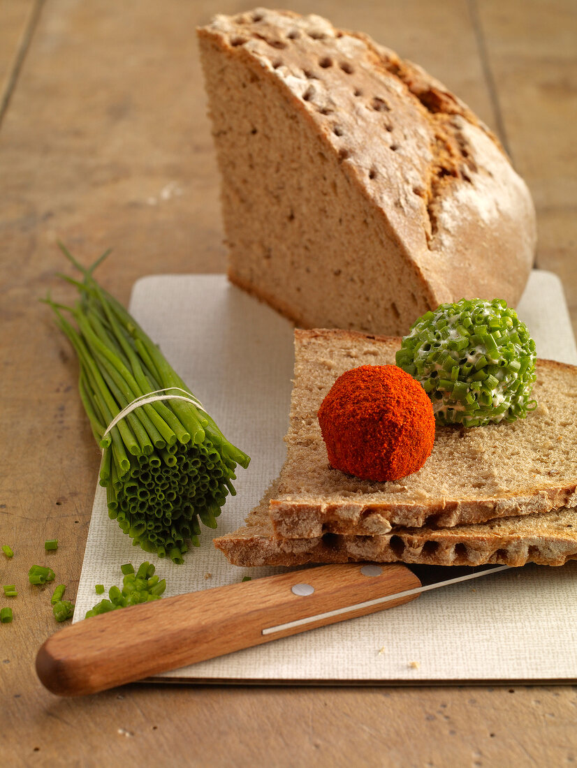 Cheese balls coated with peppers and chives on slices of bread