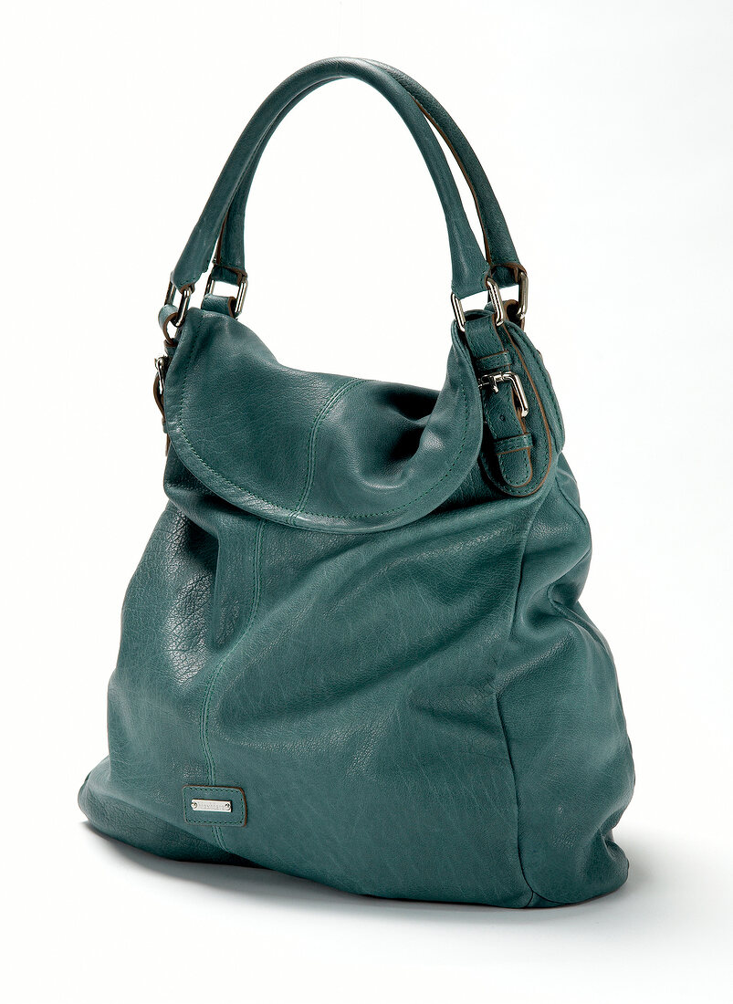Close-up of turquoise leather handbag on white background