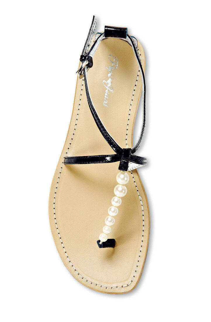 Close-up of sandal with beaded straps on white background