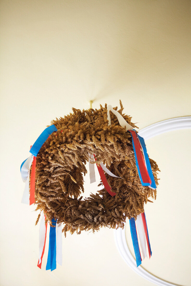 Laurel wreath with red, white and blue ribbons hanging on ceiling